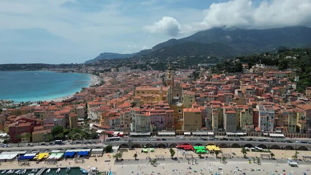 Plage des Sablettes beach in Menton France and old town with Saint Michel Basilica, Aerial approach shot