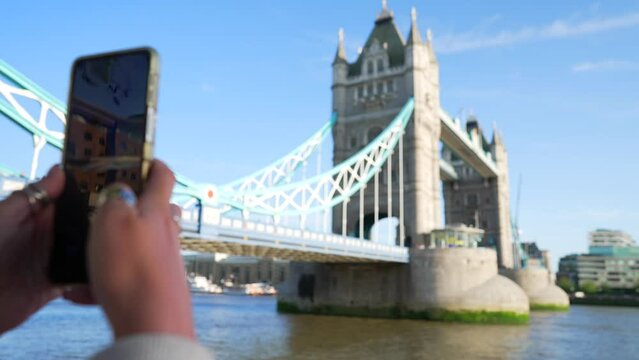 point of view phone taking picture, of Tower Bridge London, tourist picture, phone goes down, focus pull to the landmark. POV shot, bright sunny weather london city tourism. person takes photo.