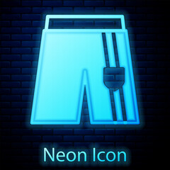 Glowing neon Short or pants icon isolated on brick wall background. Vector