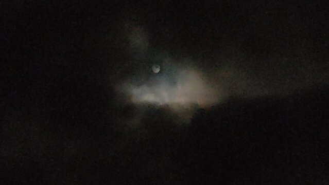 Full moon that rises untamed among the thick clouds on a gloomy night in Tenerife