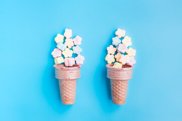 Multicolored Marshmallows out of ice cream cone on blue background, Flower Shaped Marshmallows
