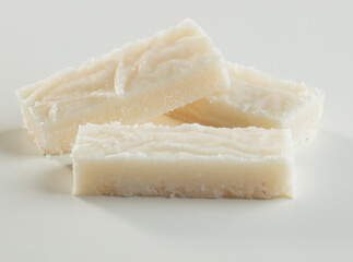 Turrón de coco blanco sobre fondo blanco, navidad.. White coconut nougat on a white background, christmas.