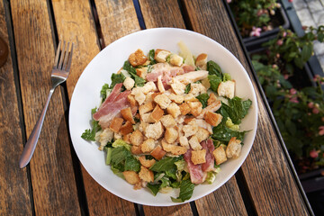 Caesar salad with croutons, bacon and chicken meat