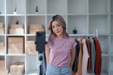Beautiful Asian woman, blogger, blog, presenting fashion clothes, live video, social media, record her, sell online via digital cameras, sme or small business ecommerce concepts