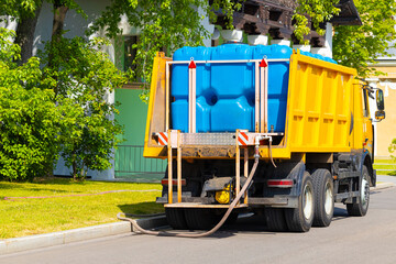 a large watering machine fills a tank with water