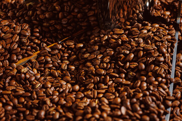 Process roasting coffee beans on professional mixing roaster machines, brown background top view