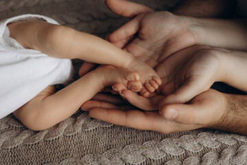 parents hold a newborn's feet in their hands
