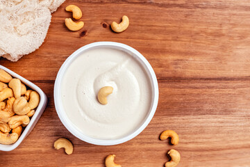 Cream cheese made of cashew on wooden table, healthy vegan alternative