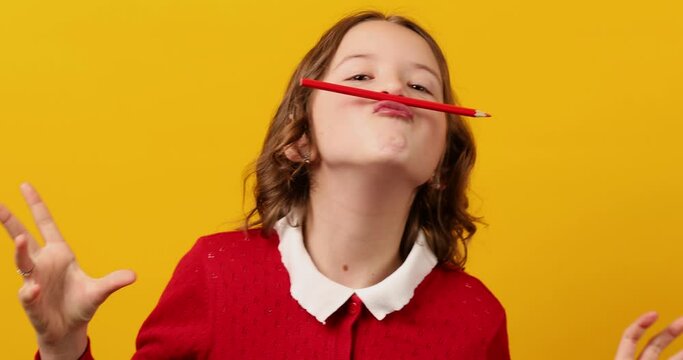 Funny teen school girl make mustache on her face with red pencil