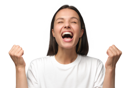 Close-up of emotional european woman showing white teeth while screaming with joy, holding hands in gesture of winner, isolated on gray background