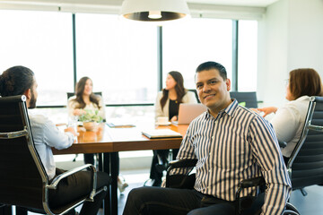 Mid adult disabled businessman sitting in office meeting with colleagues