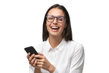 Young business woman laughing while reading text messages from colleagues on her phone, dressed in white collar shirt