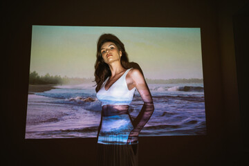 Young adult woman 20 years old with projected image of ocean or sea in neon colors