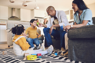 Family home, kids and parents with toys, living room and playful on floor with talking, laughing and games. Men, women and children with building blocks, development and learning in lounge in house