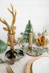 Weihnachtlich gedeckter Tisch mit Hirsch in grün, weiß und gold