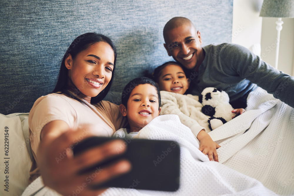 Poster Parents, children or family selfie in a bed together with love, care and security or comfort. Woman, man and kids with a happy smile for quality time or profile picture in a home bedroom to relax