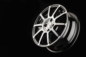 Thin-spoke cast disc, sports wheel on a black background, minimalism.