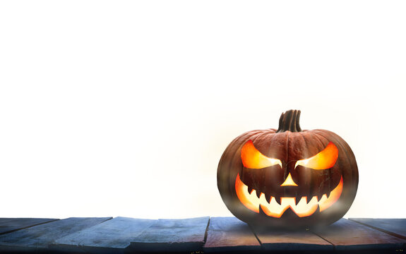 A single lit Jack-o-Lantern, halloween pumpkin lantern on a wooden product display table with an isolated transparent background.