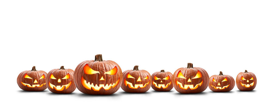 A group of eight lit spooky halloween pumpkins, Jack O Lantern with evil face and eyes isolated against a transparent background.
