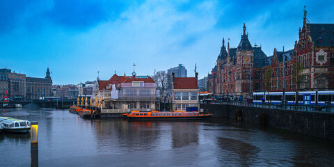 Obraz premium Amsterdam City Skyline, the marina of Open Havenfront Canal, and Central Station in rain in the Netherlands