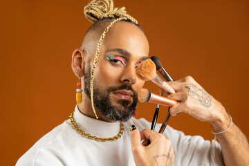 African american gay applying make up isolated on orange background