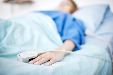 Person, hand or sleeping in hospital bed for medical treatment, surgery and icu operation in clinic. Tired, blur or sick patient lying or resting in emergency room for healthcare or wellness recovery