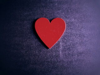 Wooden red heart with purple vintage background.