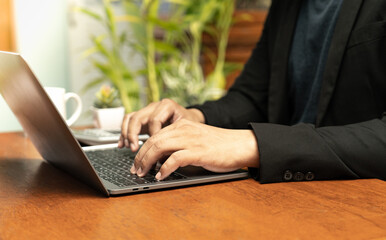 person's hand deftly manipulated both mobile phone and notebook, engaged in the realm of online shopping. With focused attention, their fingers scrolled through vibrant interface of the mobile device,