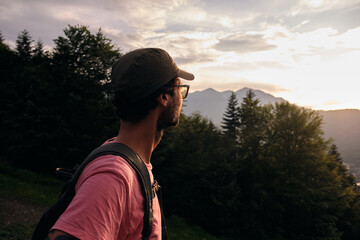Back view of hiker admiring sunset.Nature view of mountains and hills with woods at sunset.Mountain...