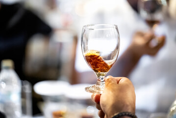 Close up of copa glass with splashing rum in a male hand. Best room tasting liquors events