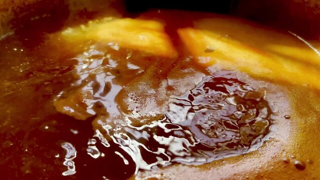 Cooking tomato sauce from fresh tomatoes in a pot