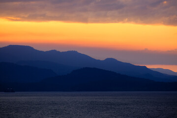 Sunset with pink, orange and purple sky above Inside Passage in British Columbia, Canada seen from...