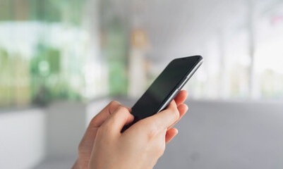 Hand using smartphone in public areas, During leisure time. The concept of using the phone is essential in everyday life.
