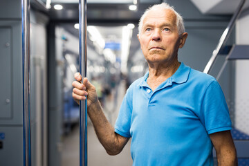 Fototapeta na wymiar Old man standing in subway car