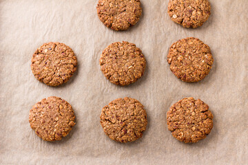 Healthy oatmeal cookies with dates, nuts and flaxseed on baking paper, top view. Delicious homemade vegan baking - 622305116