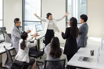 Cheerful Chinese business people applauding in office