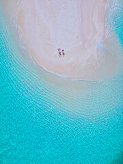 couple of men and women at a white sandbank in the ocean of Koh Lipe Island Southern Thailand, with turqouse colored ocean and white sandy beach sandbar at Ko Lipe on a sunny day