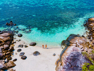 Kla Island Koh Lipe Thailand is a small island on the coast of Ko Lipe with a coral reef and great snorkeling place, couple men and women on the beach seen from a drone view © Fokke Baarssen
