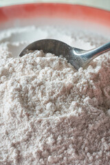 close-up view of rice flour with spoon, form of flour made from finely milled rice grains, natural gluten-free common substitute for wheat flour, selective focus with copy space