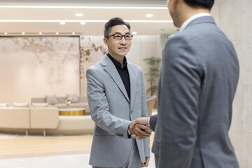 Successful Chinese business people shaking hands