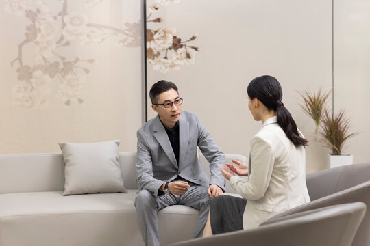 Confident Chinese business people talking in meeting room