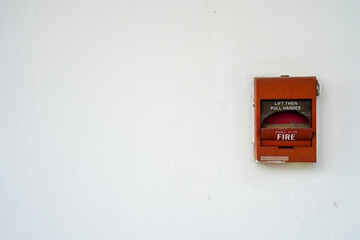 Broken red fire alarm box against clean white wall with copy space for text