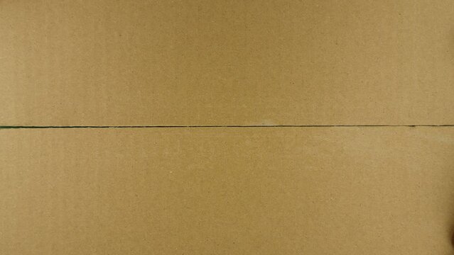 Box opening. Hand opens carton parcel with chroma key inside, view from top