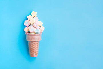 Multicolored Marshmallows out of ice cream cone on blue background, Flower Shaped Marshmallows 