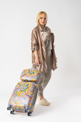 Woman tourist in casual clothes, with a large travel suitcase for travel.