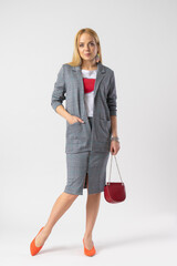 Blonde woman in elegant casual plaid office clothes with a handbag on a chain