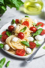 Spaghetti with mozzarella, tomatoes, basil and pesto sauce. Pasta Caprese