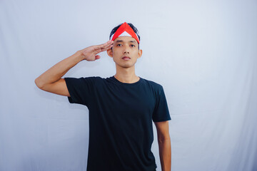 Young Asian man with indonesian flag clenched hand for celebrate Indonesia independence day on August 17, looking at camera with confident and excited expression isolated on white background