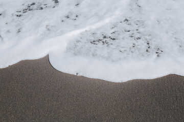 Textured airy sea foam. White waves of the ocean on the shore