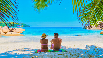 Obraz premium Anse Lazio Praslin Seychelles, a young couple of men and women on a tropical beach during a luxury vacation in Seychelles